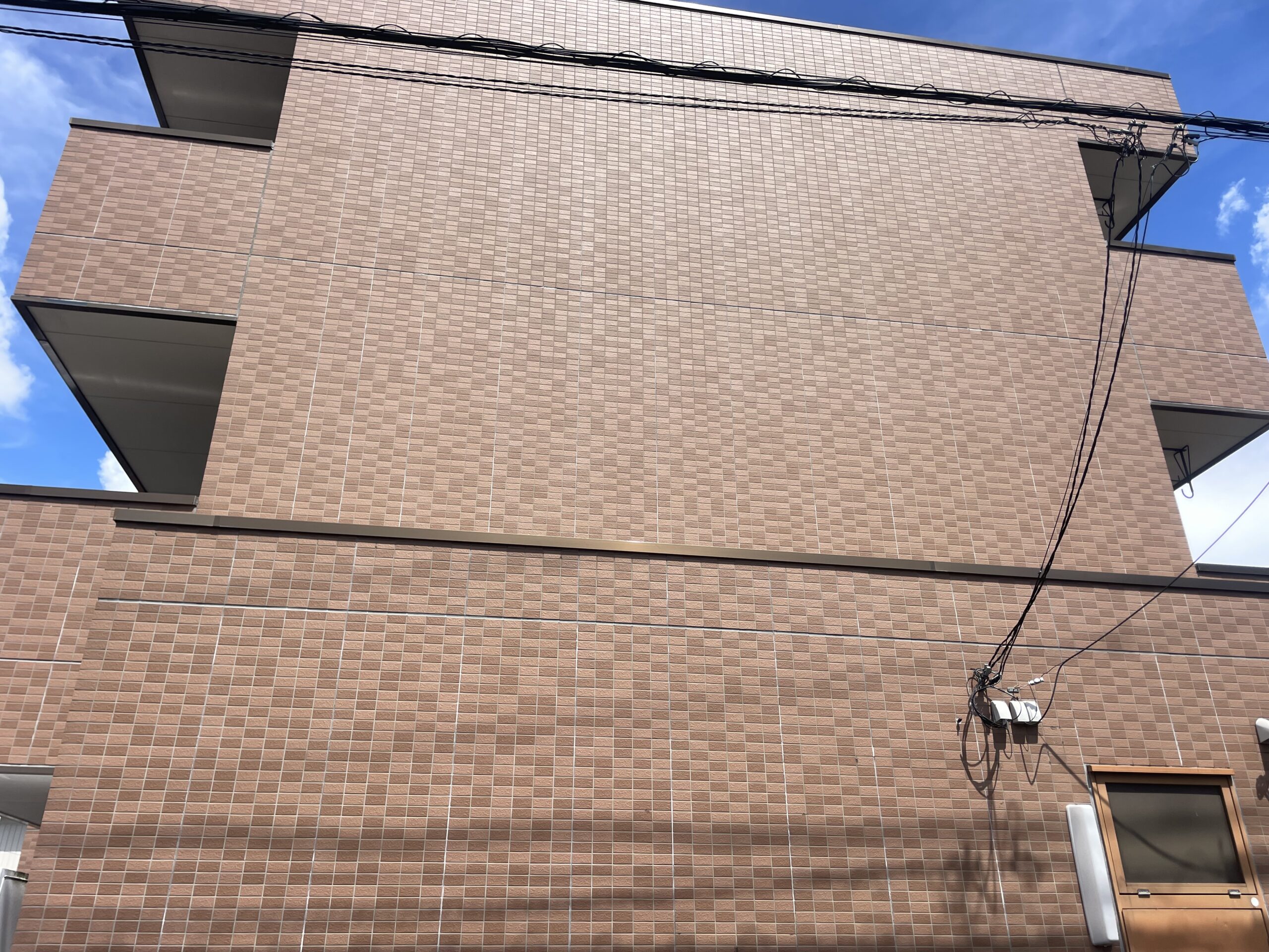 川越市のマンションで外壁を茶色から明るいホワイト系に、コーキングも全て打替えてタイルにはクリアー塗装を行いました。施工前